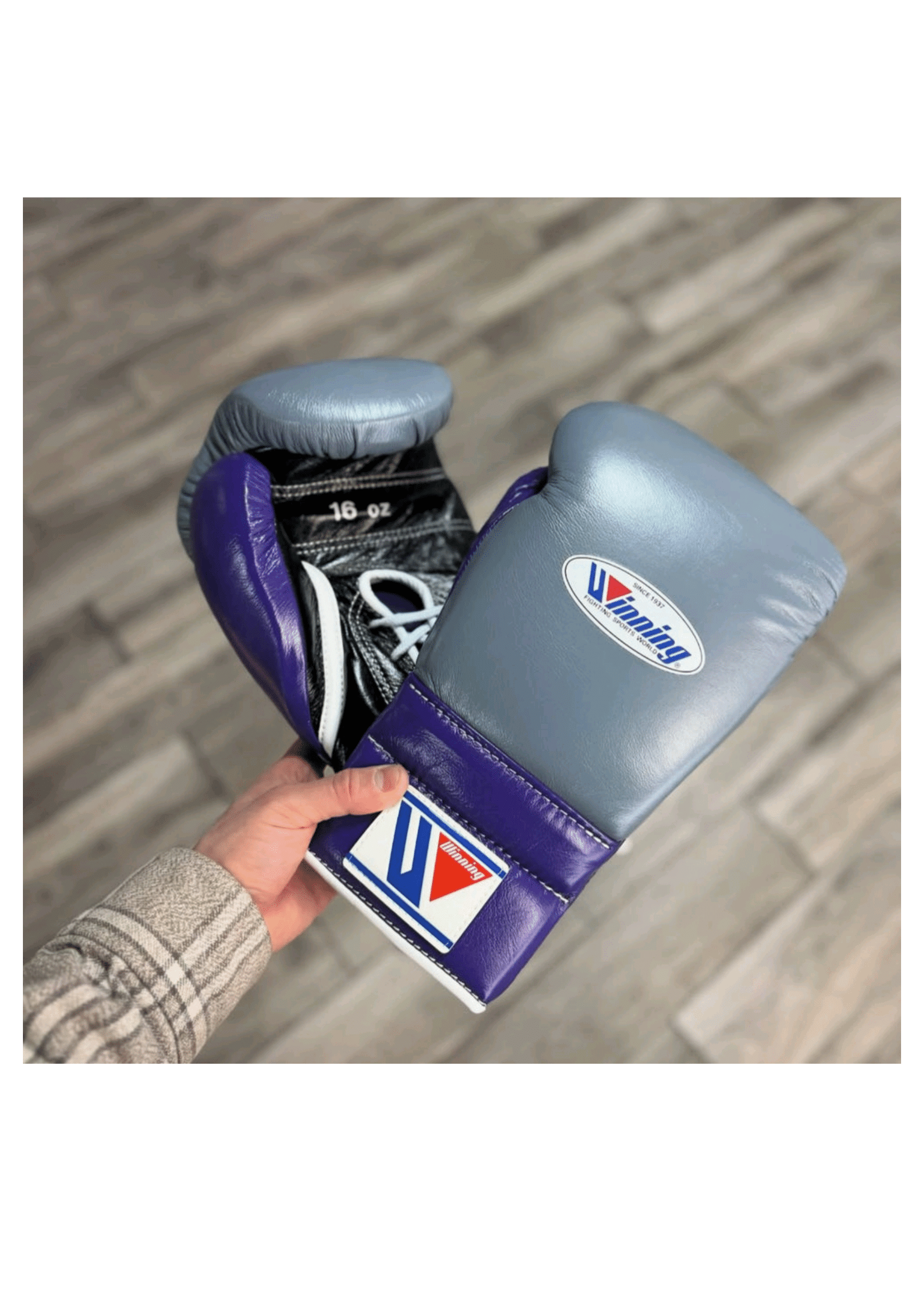 Custom Winning professional lace-up training boxing gloves in metallic gray and purple premium leather, featuring white lacing, white edge piping, and the iconic brand logo crest on the cuff.