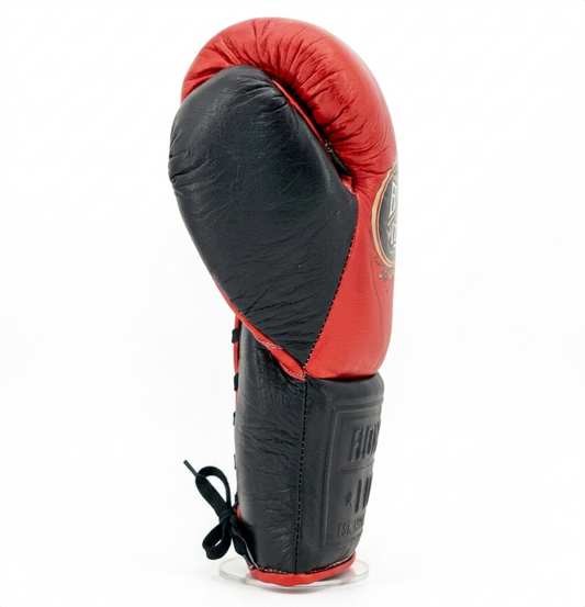 Single red and black boxing glove standing upright showing compact padded profile