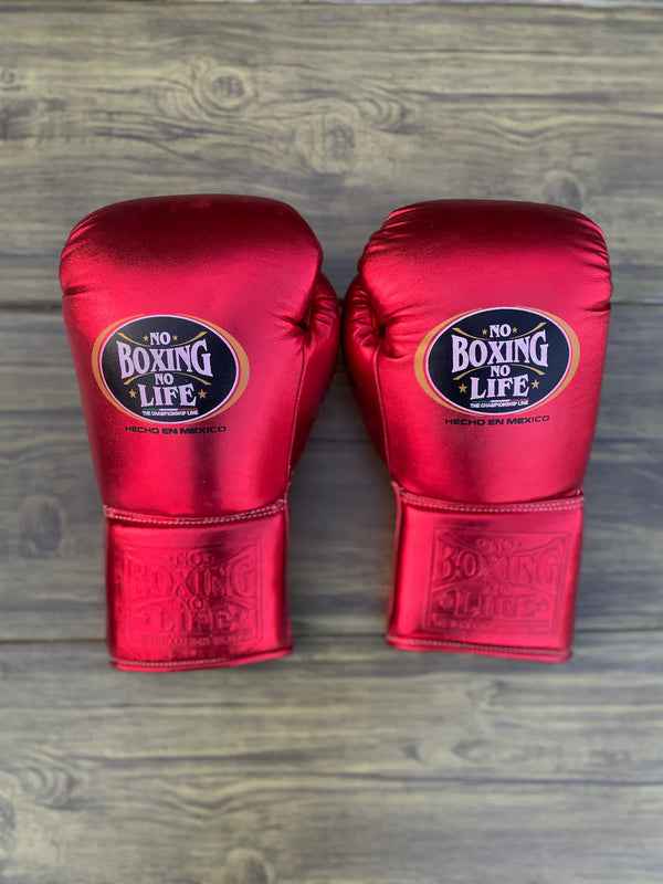 Official No Boxing No Life professional lace-up boxing gloves in metallic red leather showing the iconic black oval brand logo patch on the knuckles and an embossed logo on the cuff.